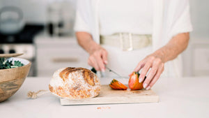 Person cutting up bread and salad