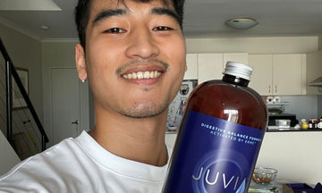 Justin smiling and holding a bottle of JUVIA