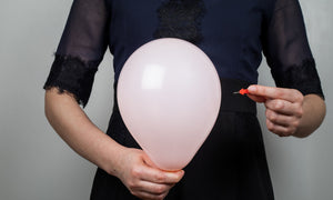 Lady holding a balloon and a pin