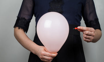 Lady holding a balloon and a pin