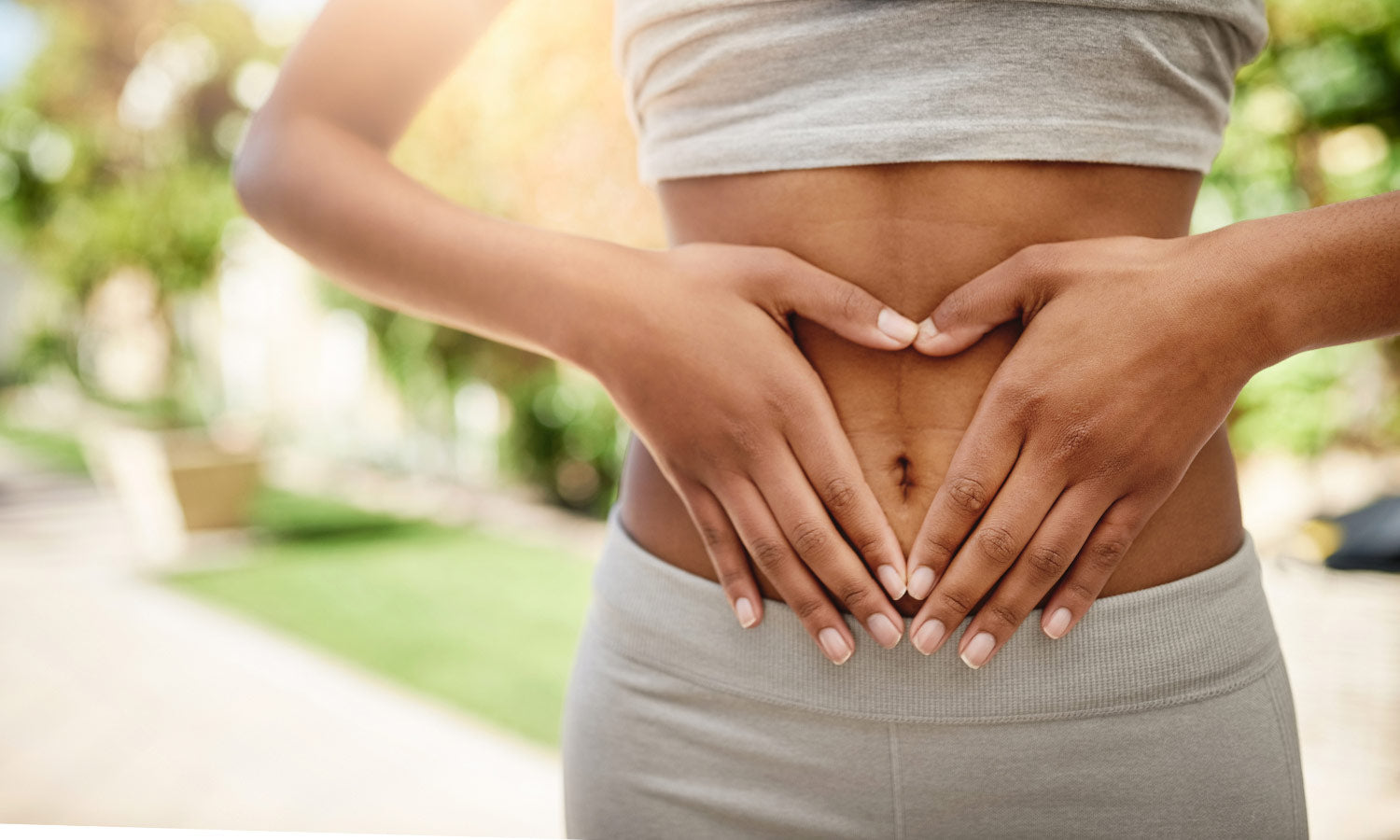 Lady making a heart shape with her hands on her tummy