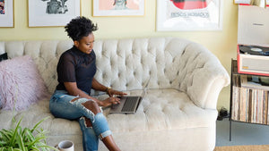 lady sitting on the sofa working on a laptop